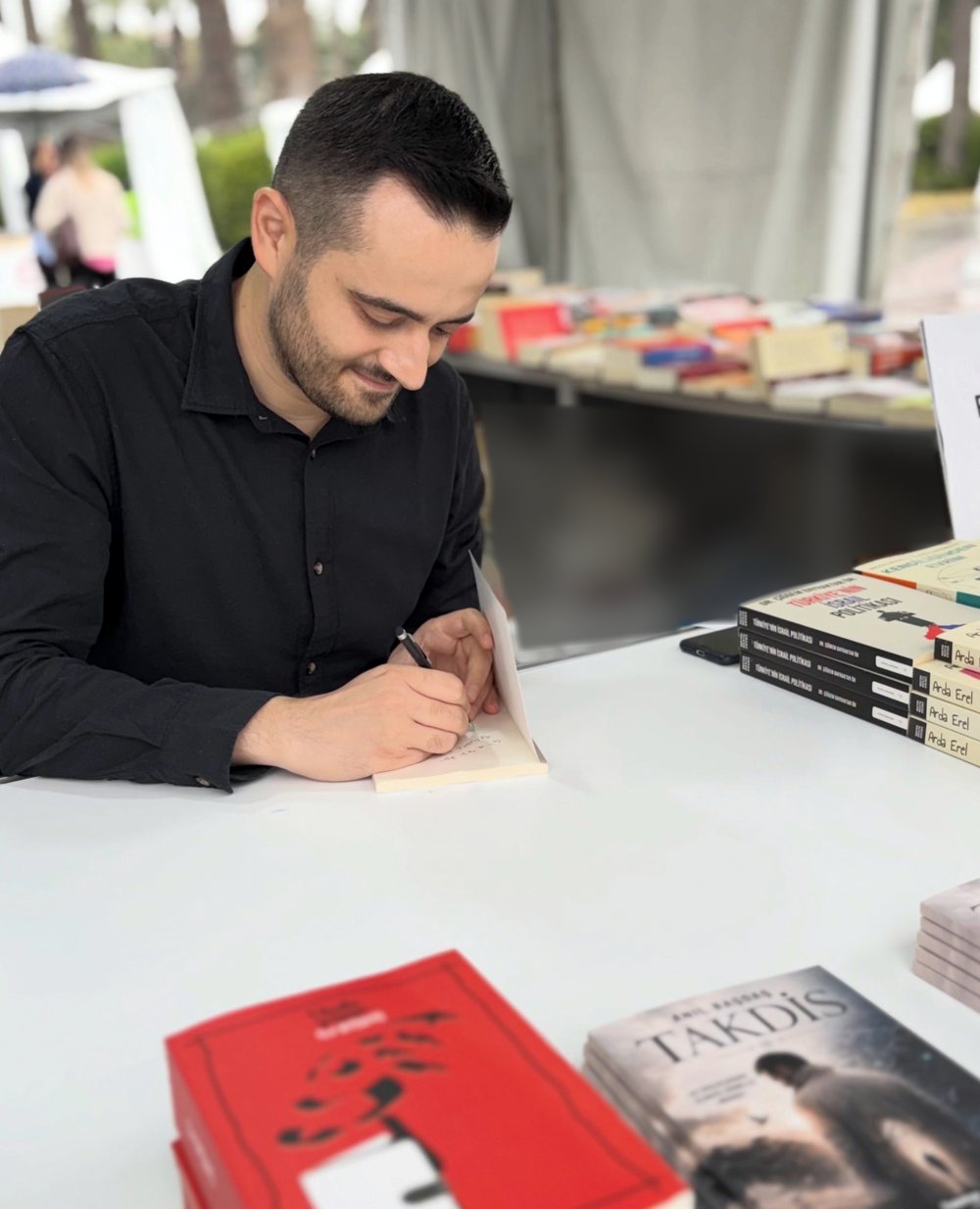 Anıl Başdaş imza gününde kitap imzalıyor